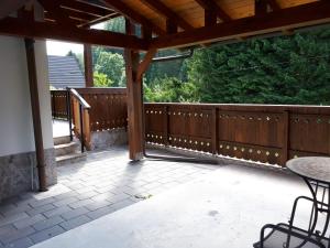 a wooden deck with a table and chairs on a patio at Apartment Alpska Astra in Kranjska Gora