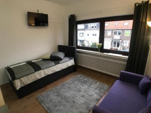 um quarto com uma cama e uma grande janela em Living @ Klassvilla Weserwehr No. 3 em Bremen