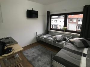 ein Wohnzimmer mit einer Couch und einem Fenster in der Unterkunft Living @ Klassvilla Weserwehr No. 4 in Bremen