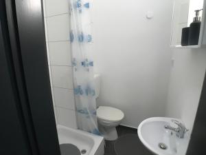 ein weißes Bad mit einem WC und einem Waschbecken in der Unterkunft Living @ Klassvilla Weserwehr No. 4 in Bremen