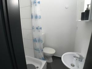 ein weißes Badezimmer mit Toilette und Waschbecken in der Unterkunft Living @ Klassvilla Weserwehr No. 4 in Bremen