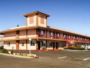 a large building with a parking lot in front of it at Park Avenue Inn & Suites in Victorville