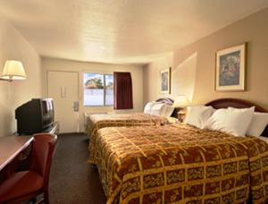 una camera d'albergo con due letti e una televisione di Park Avenue Inn & Suites a Victorville