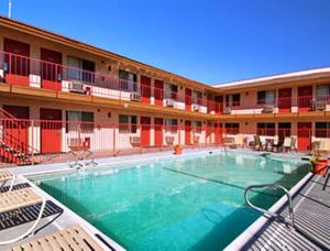 a swimming pool in front of a building at Park Avenue Inn & Suites in Victorville