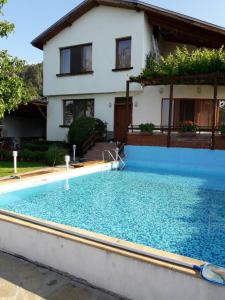 uma casa com piscina em frente a uma casa em House Mirlevi em Shipka