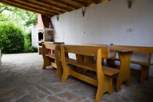 una mesa de madera y bancos en un patio en House Mirlevi en Shipka