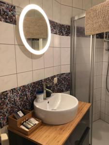 ein Badezimmer mit einem weißen Waschbecken und einem Spiegel in der Unterkunft Villa Baltia in Graal-Müritz