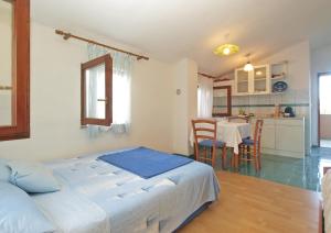 a bedroom with a bed and a kitchen with a table at Apartments Milan 1665 in Peroj