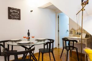 ein Esszimmer mit einem Tisch mit Stühlen und Weingläsern in der Unterkunft JOIVY Charming apt near Fado Museum in Lissabon