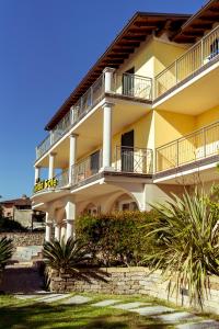 un gran edificio amarillo con balcones. en Hotel Splendid Sole, en Manerba del Garda