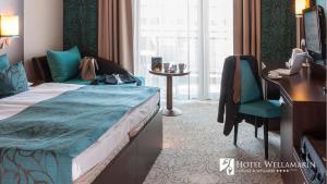 a hotel room with a bed and a desk at Hotel Wellamarin in Zamárdi
