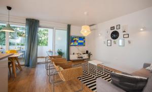 uma sala de estar com um sofá, uma mesa e cadeiras em Apartment Skradinska 11 em Split