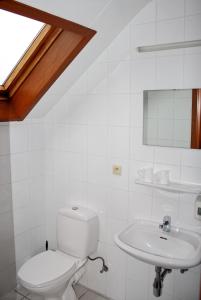 a white bathroom with a toilet and a sink at Hotel Plaza in Lommel