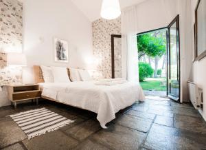 a white bedroom with a bed and a large window at Villa Irini in Sani in Sani Beach +41 photos