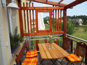y balcón con mesa y sillas de madera. en Ferienwohnung Lindemann, en Weißig