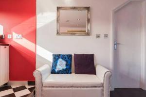 een woonkamer met een stoel en een spiegel bij Studio flat 15 min from Greenwich ( en-suite) in Plumstead