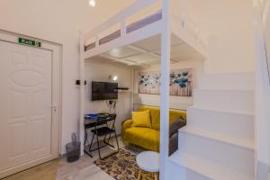 ein Wohnzimmer mit einem gelben Sofa und einer Treppe in der Unterkunft Valletta Spacious Duplex - St.Paul's Apartments in Valletta