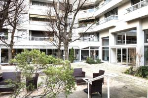 a building with benches in front of a building at Domitys Paris Plaisance in Paris