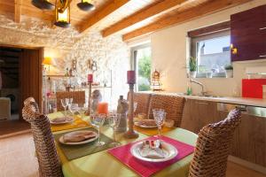 Old Stone House في أرتشانيس: غرفة طعام مع طاولة مع كراسي ومطبخ