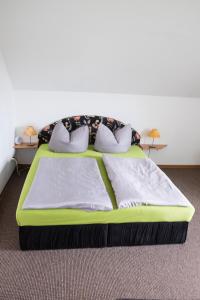 a green bed in a room with two pillows at Am Zirkelstein 38 b in Schöna