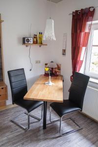 a dining room table with two black chairs and a table at Am Zirkelstein 38 b in Schöna