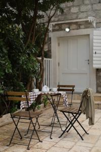 una mesa y sillas en un patio con garaje en Seven Hills Duplex Eco-Cottage en Kotor