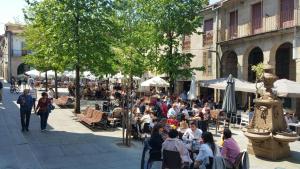 una multitud de personas sentadas en mesas en una calle en Verdura Suites ArchSense Apartments, en Pontevedra