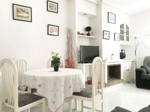 a dining room with a table and chairs and a tv at Apartamento CalarAlto 7 in Torrevieja
