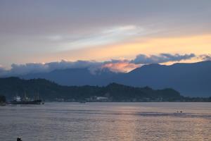 una puesta de sol sobre el agua con montañas en el fondo en Ancyra by Continent - Poso en Poso