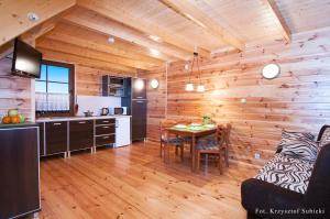 a kitchen and dining room with a table in a cabin at Domki letniskowe IWET in Darłowo