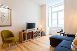 uma sala de estar com um sofá e uma televisão em JOIVY Modern 1-bed Apt nearby Praça do Comércio, in Baixa em Lisboa
