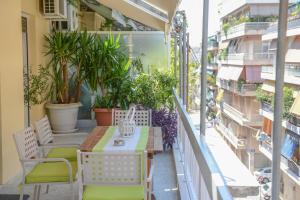 einen Balkon mit einem Tisch, Stühlen und Pflanzen in der Unterkunft City apartment 17 in Athen