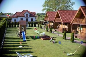 a yard with houses and a playground with swings at Domki letniskowe IWET in Darłowo