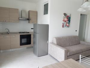 ein Wohnzimmer mit einem Sofa und einem Kühlschrank in der Unterkunft il Gelsomino in Formia