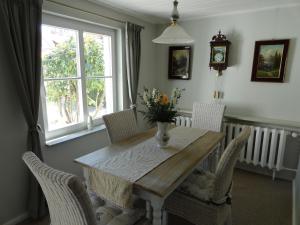 a dining room table with chairs and a vase of flowers on it at Cottage Ferienwohnung mit Seeblick in Caputh