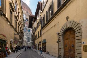 an alley with people walking down a street between buildings at Apartments close to Duomo in Florence