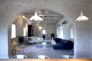 ein Torbogen in einem Wohnzimmer mit Sofas und Stühlen in der Unterkunft Torri E Merli Hotel by GHH in Lákka