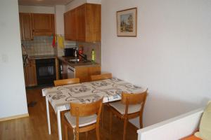 een keuken met een tafel en stoelen in een kamer bij Résidence Les Mandarins D in Crans-Montana