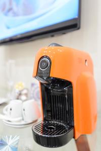 an orange blender sitting on top of a table at RHS Rienzo Suites in Rome