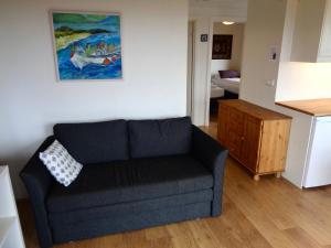 a living room with a blue couch and a kitchen at Hali Country Hotel in Gerdi