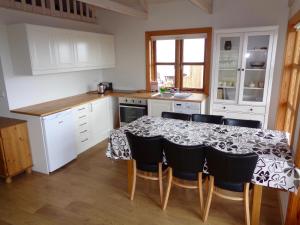 een keuken met een tafel met stoelen en witte kasten bij Hali Country Hotel in Hali