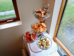 three bowls of fruit on a table next to a window at Hali Country Hotel in Gerdi