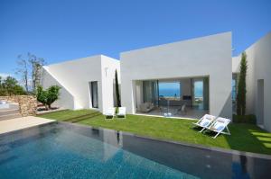 a house with a swimming pool and two lawn chairs at VILLA BONITA - REF 216 in Begur