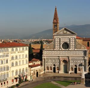 un grand bâtiment avec une tour d'horloge dans une ville dans l'établissement Grand Hotel Minerva, à Florence