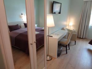 a bedroom with a bed and a table and a mirror at Hali Country Hotel in Gerdi