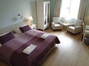 a bedroom with a large bed with two towels on it at Hali Country Hotel in Gerdi
