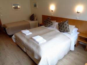 a hotel room with two beds with towels on them at Hali Country Hotel in Gerdi
