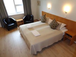 a bedroom with a large bed with two chairs at Hali Country Hotel in Gerdi