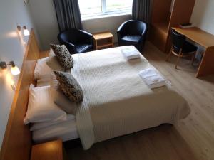 a hotel room with a bed and two chairs at Hali Country Hotel in Gerdi