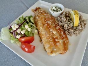 a plate of food with fish and rice and salad at Hali Country Hotel in Gerdi
